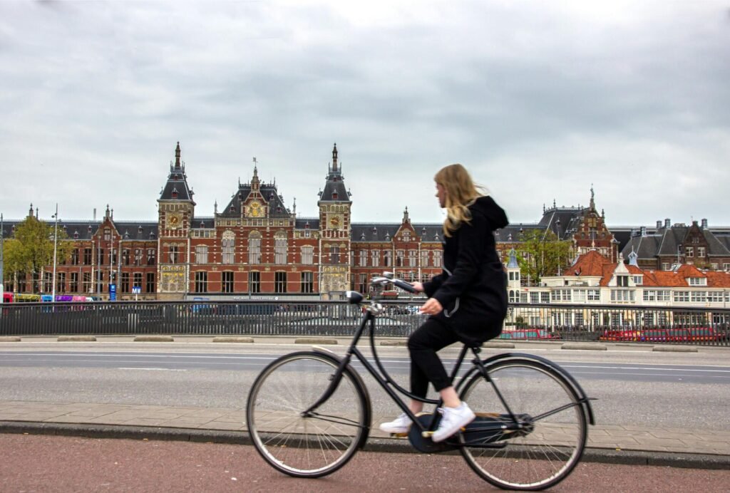 Woman biking past Amsterdam central station